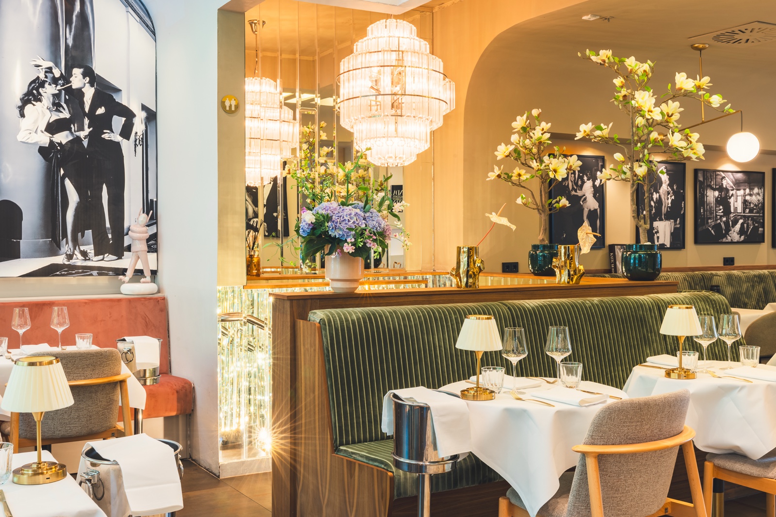 Warme abendliche Bar-Atmosphäre mit Kristalllüster, grüner Samtbank und Tresen bei Casa Bellucci in Berlin-Charlottenburg
